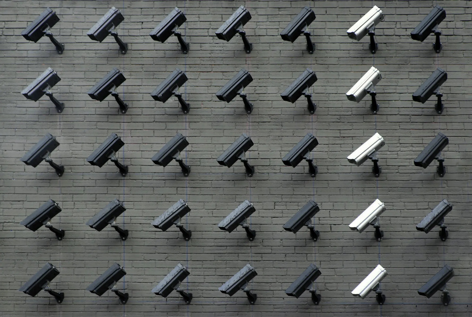 Rows of commercial security cameras mounted on a wall