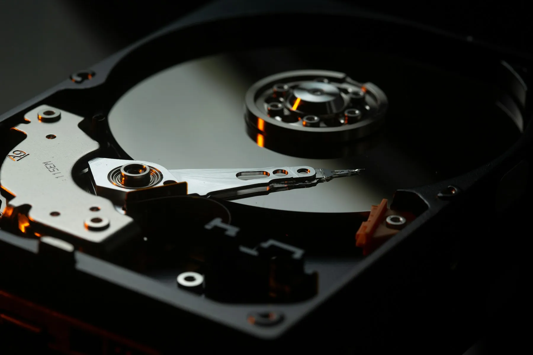 Open hard disk drive showing platter and actuator arm