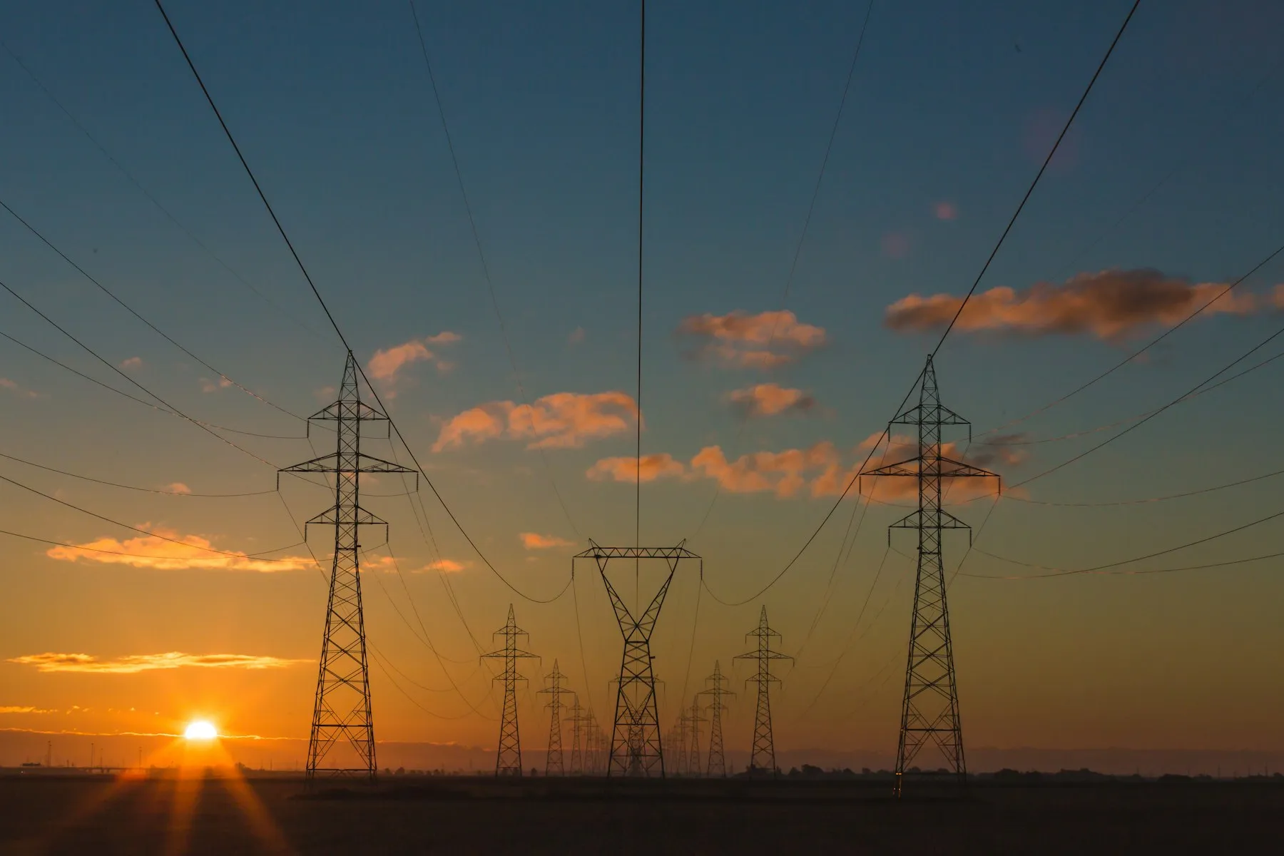 High-voltage transmission towers at sunset